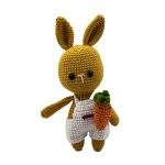 Hardal rengi amigurumi tavşan beyaz giysili ve havuçlu ön plan çekimi